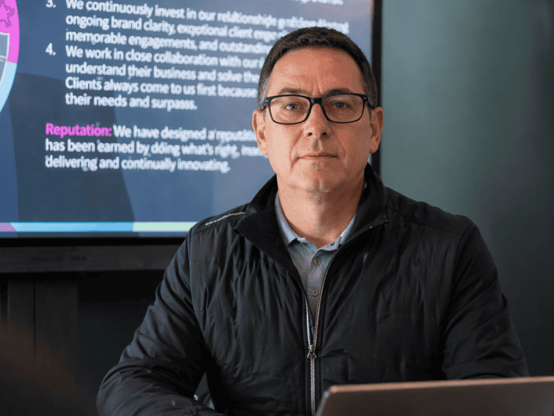 Business professional presenting data on a digital screen during a corporate meeting.