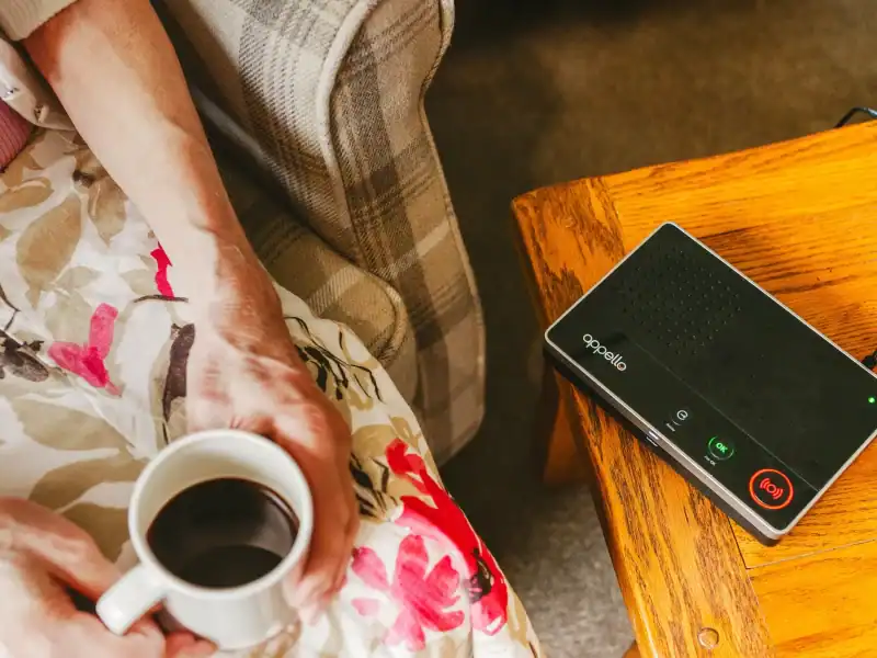 Portable speakerphone with call control buttons connected to a laptop for remote meetings.