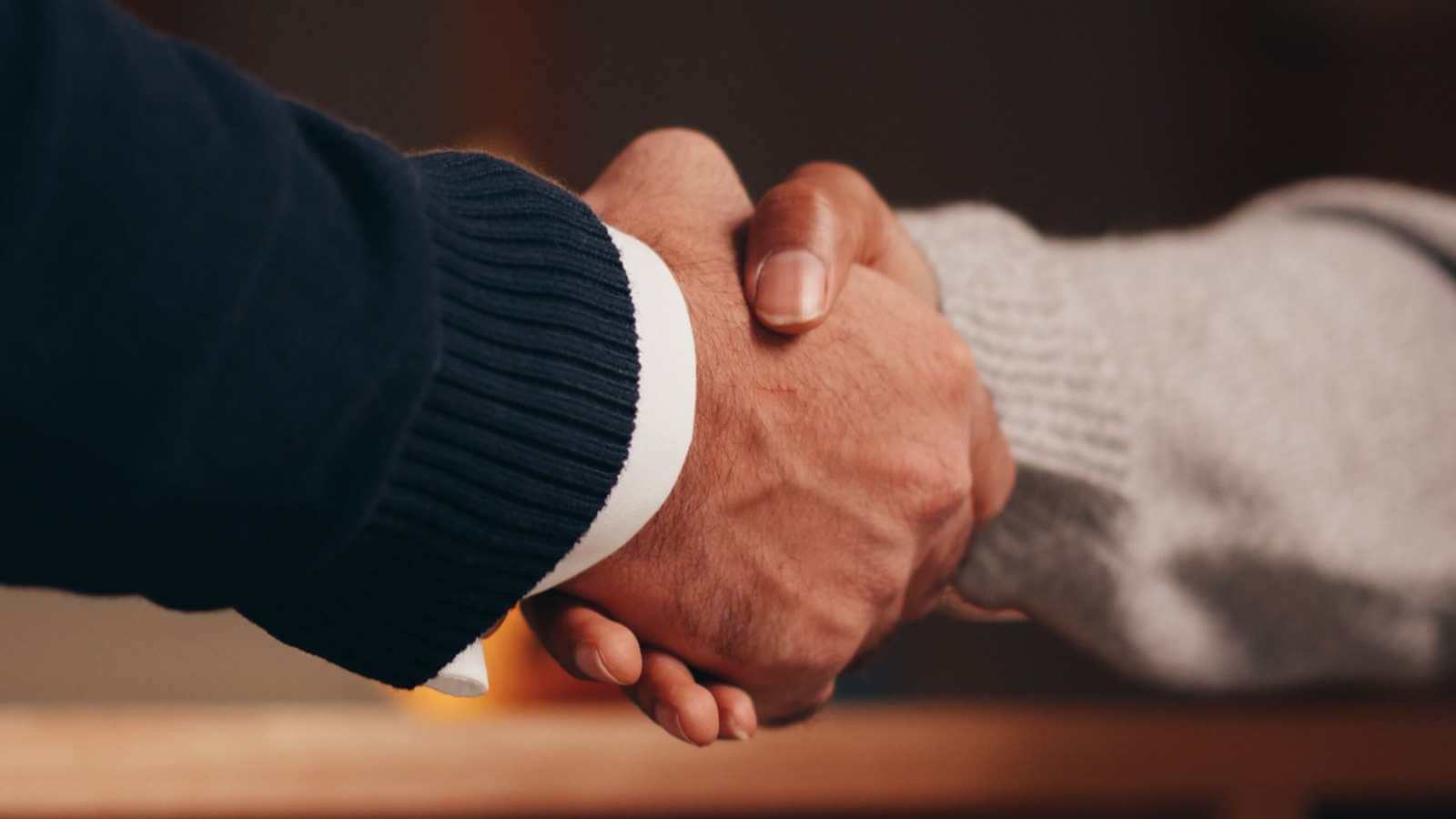 Close-up of two people shaking hands, symbolising partnership and agreement.